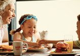 Grandmother and children eating breakfast together